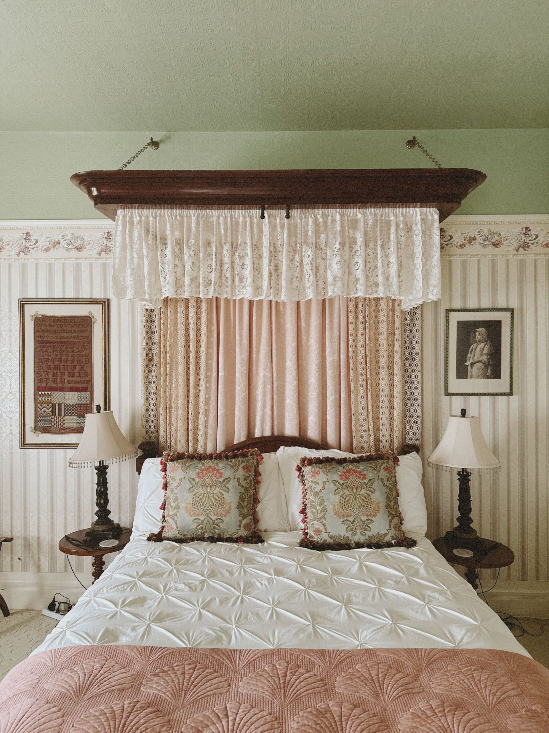 Antique half-tester bed with lace and pink damask canopy in the Victoria Suite at The Adams Pragge House